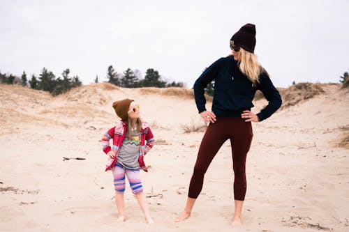 A Mother and Her Daughter Standing on the Sand