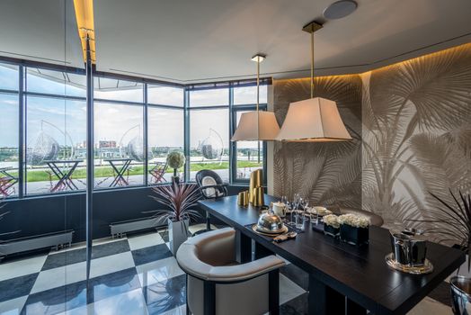 Elegant office space with modern design, featuring luxurious furniture and a scenic glass wall view.