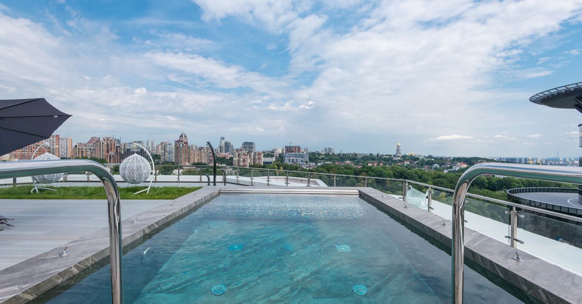Luxurious rooftop pool with cityscape backdrop, perfect blend of nature and architecture.