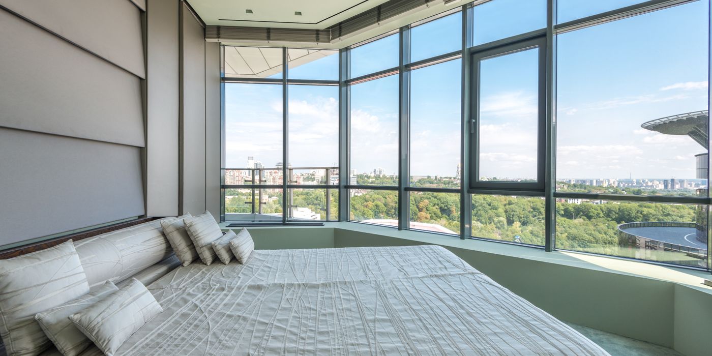 A spacious upgraded hotel room with a large bed and panoramic windows in 2026
