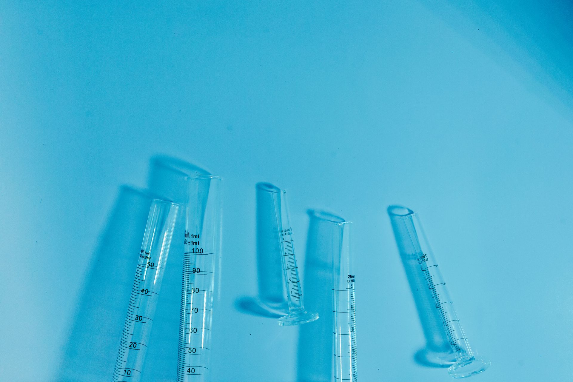 Glass Graduated Cylinders on Blue Surface
