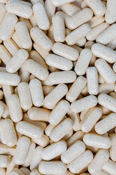 Detailed close-up of numerous white pills, showcasing texture and shape.