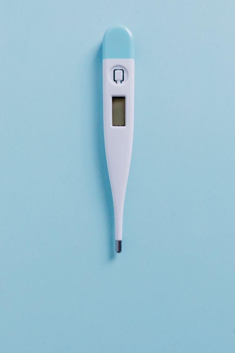 A White And Blue Digital Thermometer On Blue Surface