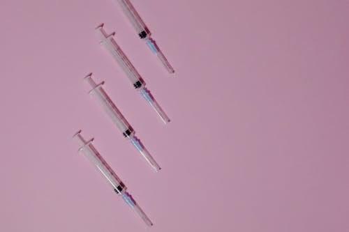 Clear Plastic Syringes on Purple Surface