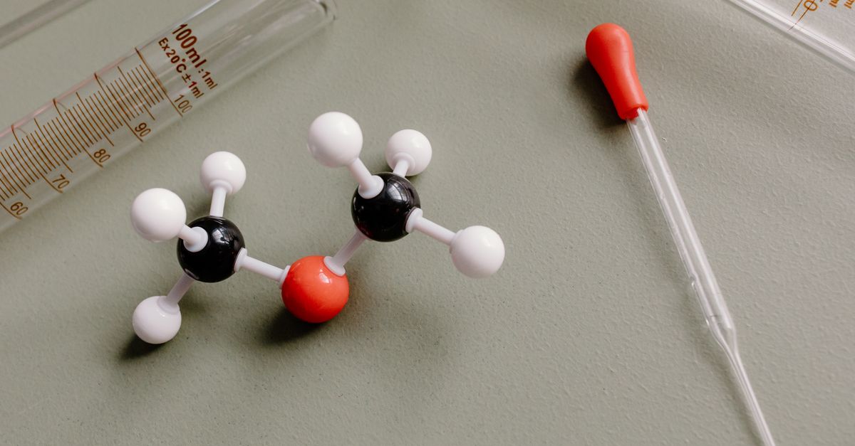 Close-up of laboratory equipment and molecular model on a flat surface.