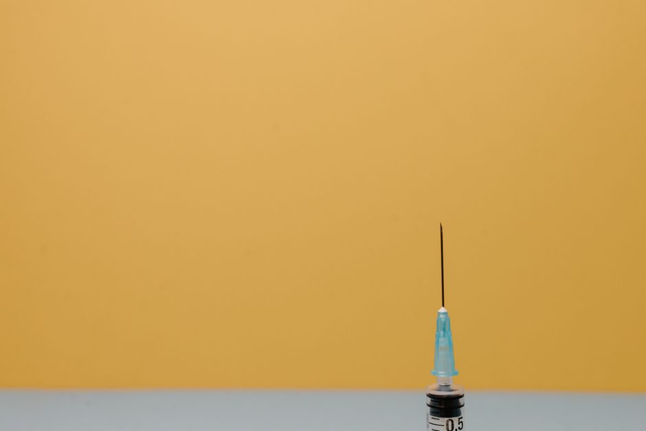 鮮やかな黄色の背景に対する医療用注射器のクローズアップ、医療テーマに最適です。