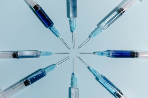 Close-Up Shot of Syringes on a Blue Surface
