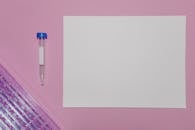 Plastic Test Tube Beside the White Paper