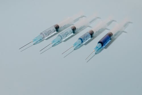 Close-Up Shot of Syringes on a Blue Surface