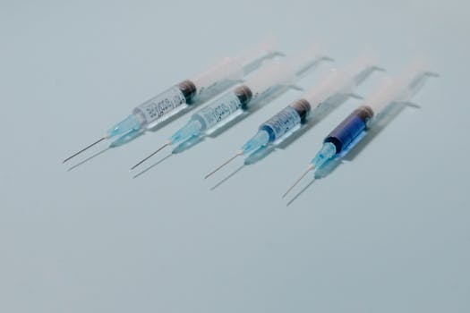 A collection of sterile syringes arranged on a blue surface, ideal for medical themes.