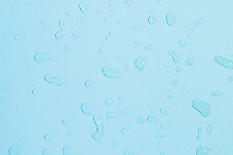 Scattered Droplets Of Water On Blue Surface