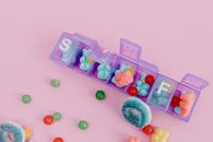 Assorted Color of Candies on Pink Plastic Container