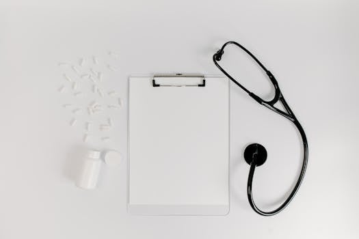 Flat lay of clipboard, pills, and stethoscope for medical use.