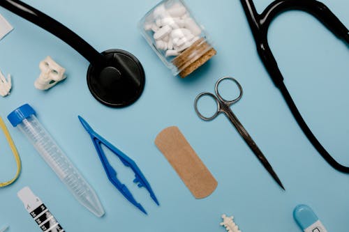 Black Handled Scissors Beside Brown Wooden Chopping Board and Blue Handled Scissors