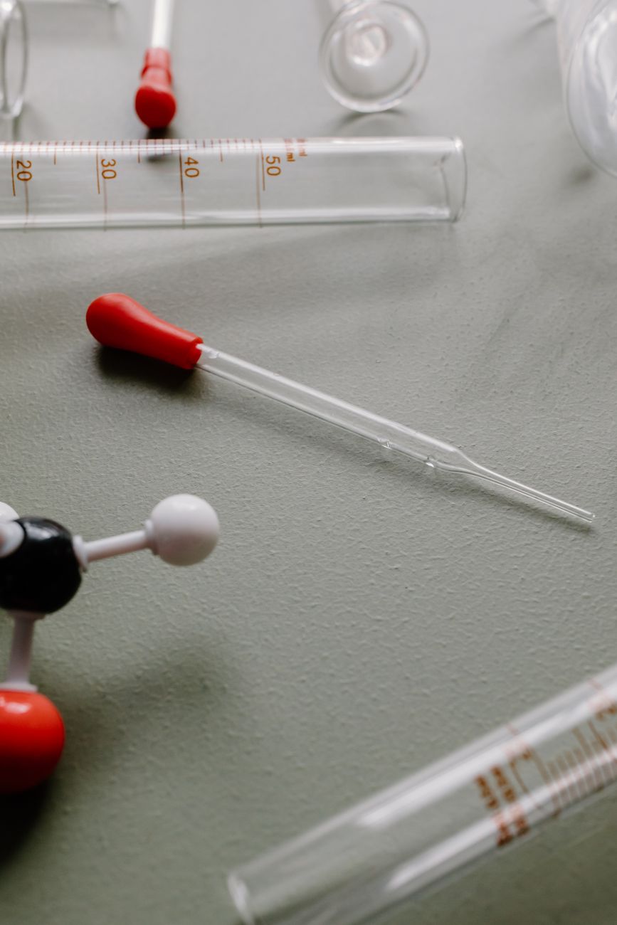Close-up of glass dropper and test tubes illustrating laboratory research on sweetener exposure and brain health.
