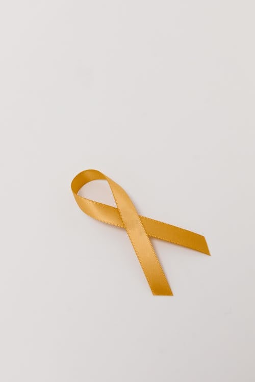 Close-Up Shot of a Gold Ribbon on a White Surface