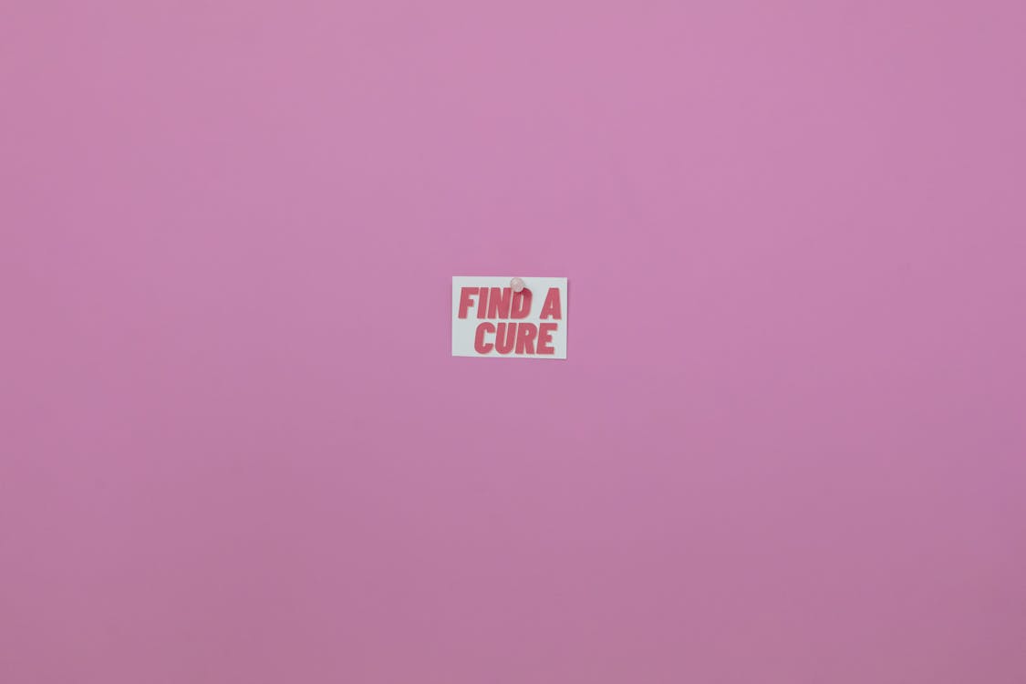 A Find a Cure on White Paper Posted on Purple Background