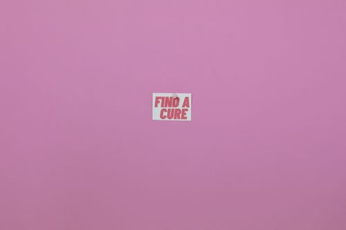 Free Minimalistic pink background with 'Find a Cure' message. Perfect for health awareness campaigns. Stock Photo