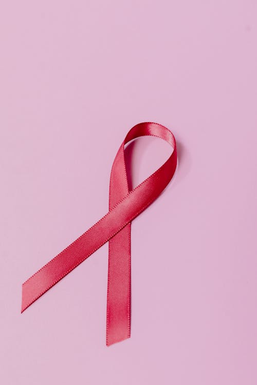Free Close-Up Photo of a Red Ribbon on a Pink Surface Stock Photo