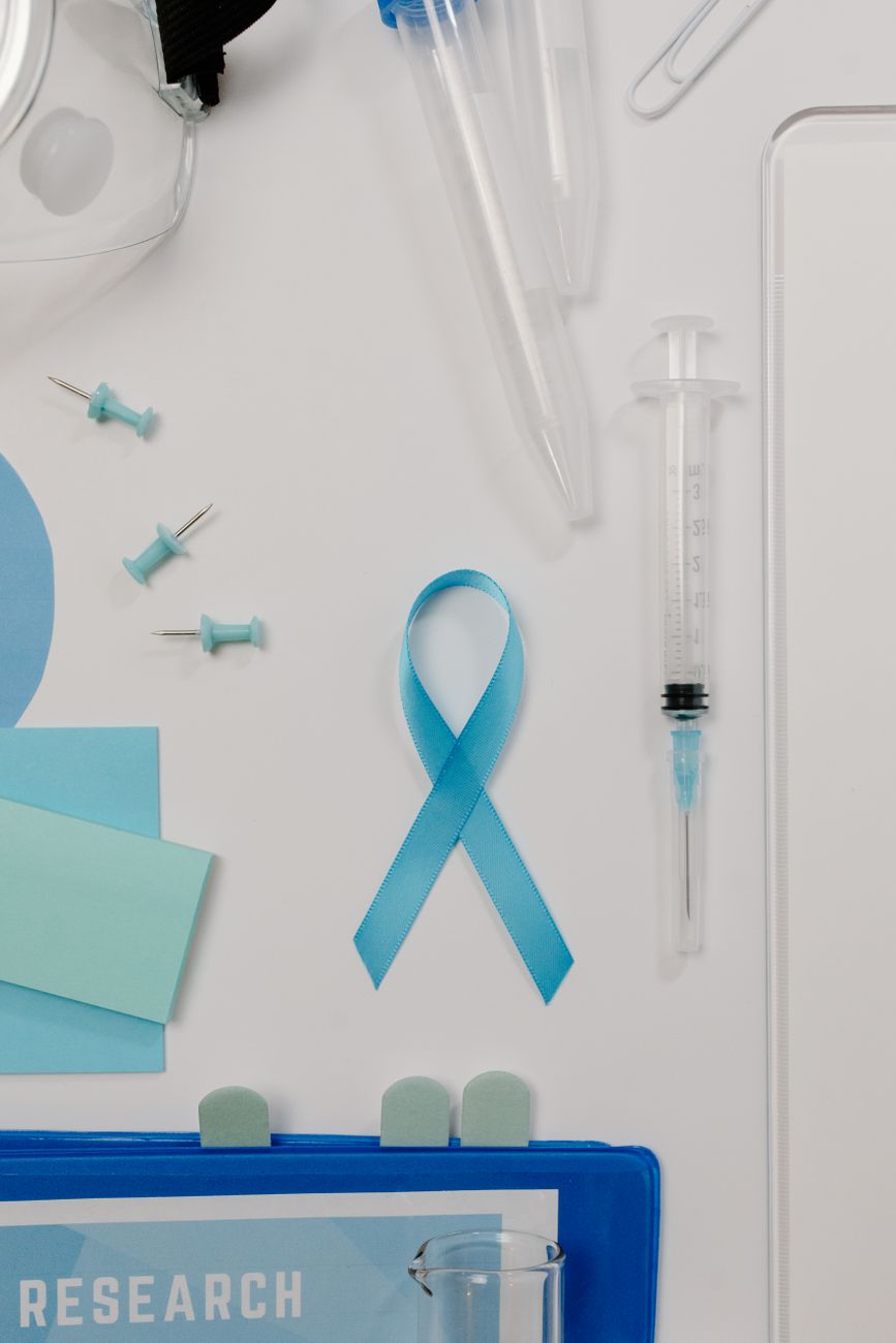 Bovenaanzicht van medische onderzoeksbenodigdheden met een blauw bewustzijnslint ter bevordering van bewustzijn over prostaatkanker.