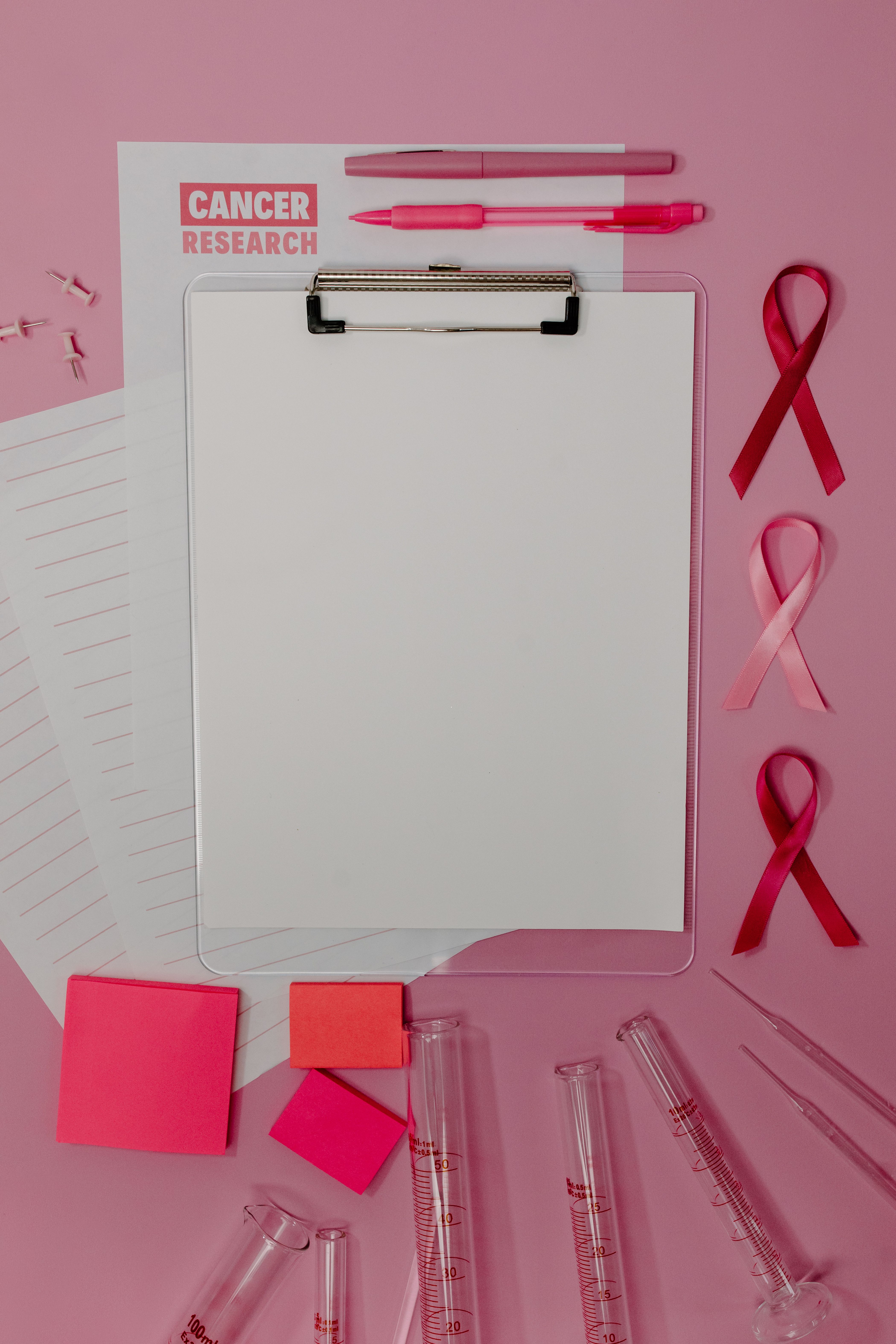 Red and Pink Cancer Ribbons Beside a Blank Paper · Free Stock Photo