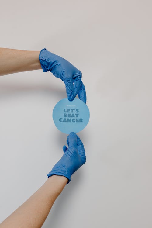 Free Person Wearing Latex Gloves Holding a Blue Paper with Message Stock Photo