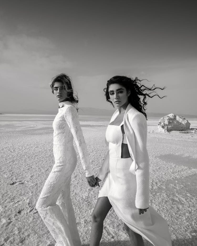 Diverse Women In Stylish Outfits Holding Hands In Desert