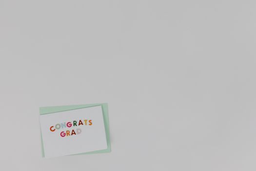 A minimalist congratulatory card for graduation on a plain white background offering ample copyspace.