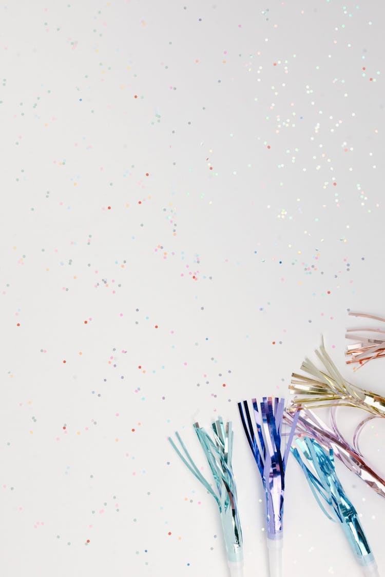 Colorful Tassels And Confetti On White Surface
