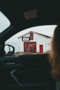 Unrecognizable woman observing old house from car