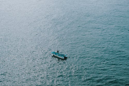 
An Aerial Shot of a Person on a Blue Boat