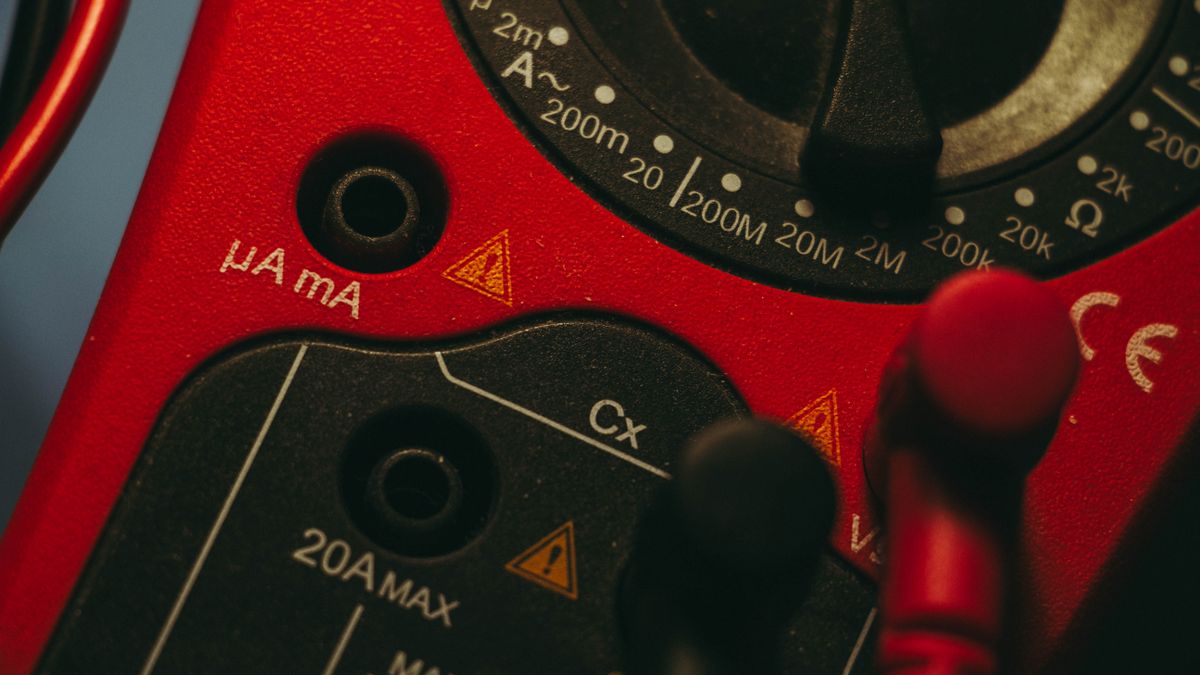Detailed image of a red multimeter, showcasing measurement dial and connectors