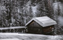 冬日宁静，白雪皑皑的小屋四周环绕着霜冻的树木