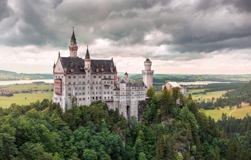 Kostenlos Luftbild Des Weißen Schlosses Mit Grünem Laubbaum Unter Weißem Bewölktem Himmel Stock-Foto