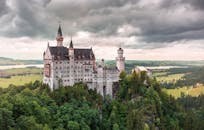 德国巴伐利亚州的新天鹅堡，被郁郁葱葱的绿色植物环绕，景色壮丽