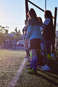 Group of women soccer players standing on the field preparing for a match during summer.