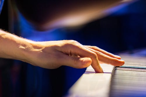 
A Close-Up Shot of a Person Pressing a Key of a Piano