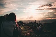 一群朋友在山上的剪影，俯瞰着风景优美的日落