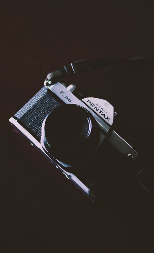 Free A classic Pentax K1000 camera captured with a nostalgic retro style. Stock Photo