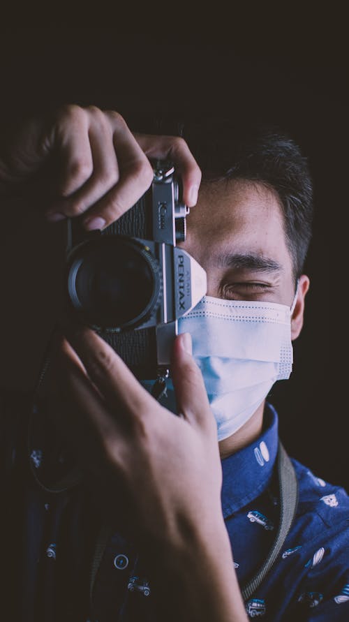 A Close up of a Masked Photographer Taking a Photo