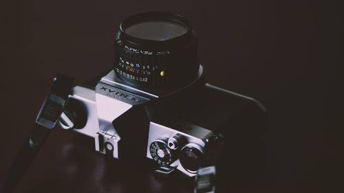 Free Close-up of a classic film camera with intricate lens details in moody lighting. Stock Photo