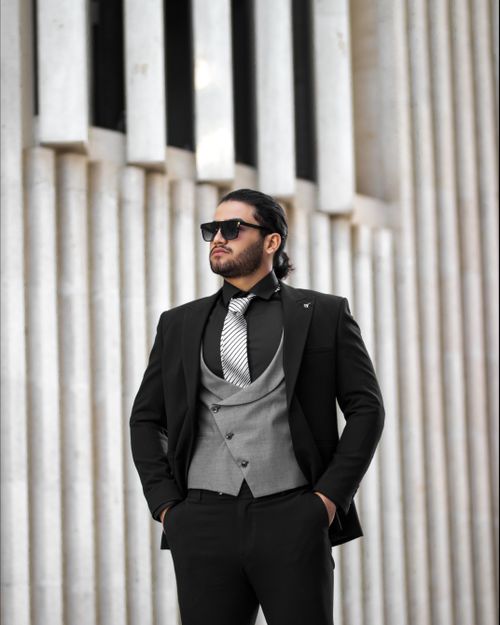 Free A fashionable man in sunglasses and suit posing confidently outdoors in Iran. Stock Photo