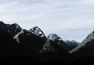 晴朗的天空映衬着白雪皑皑的山峰，展现了大自然的美丽