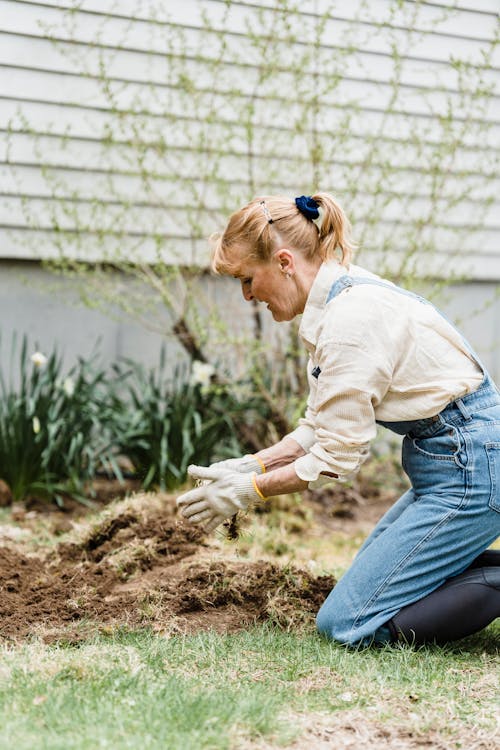 A Woman Removing the Grass from the Soil