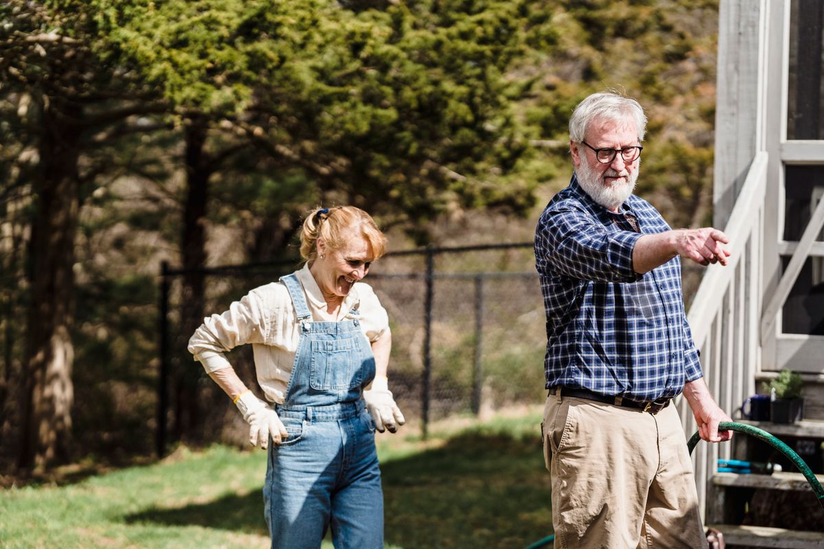 Senior couple standing together confidently in their garden