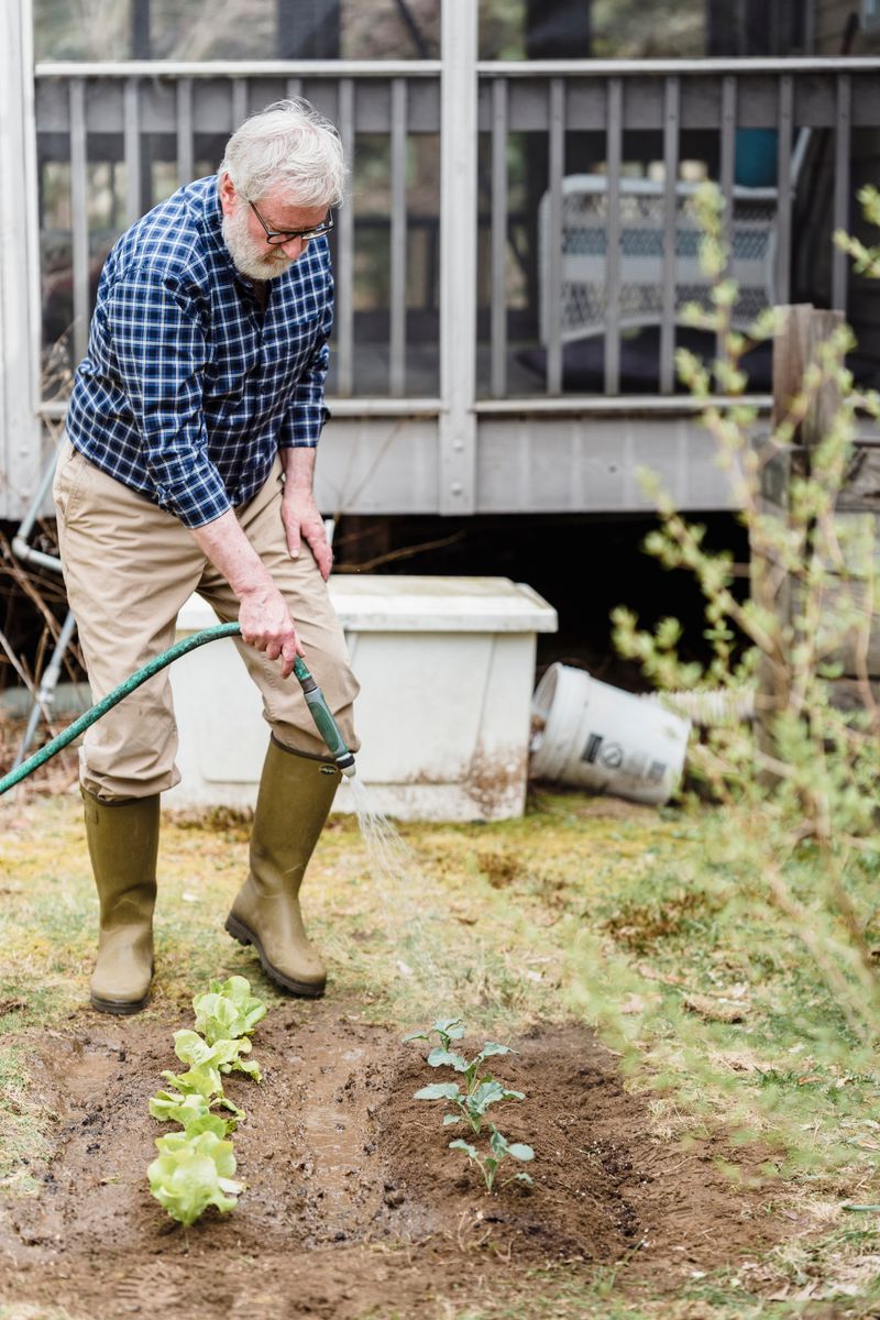 Gardener testing soil pH with a testing kit showing color comparison chart