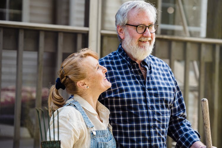 Positive Mature Couple With Garden Tools