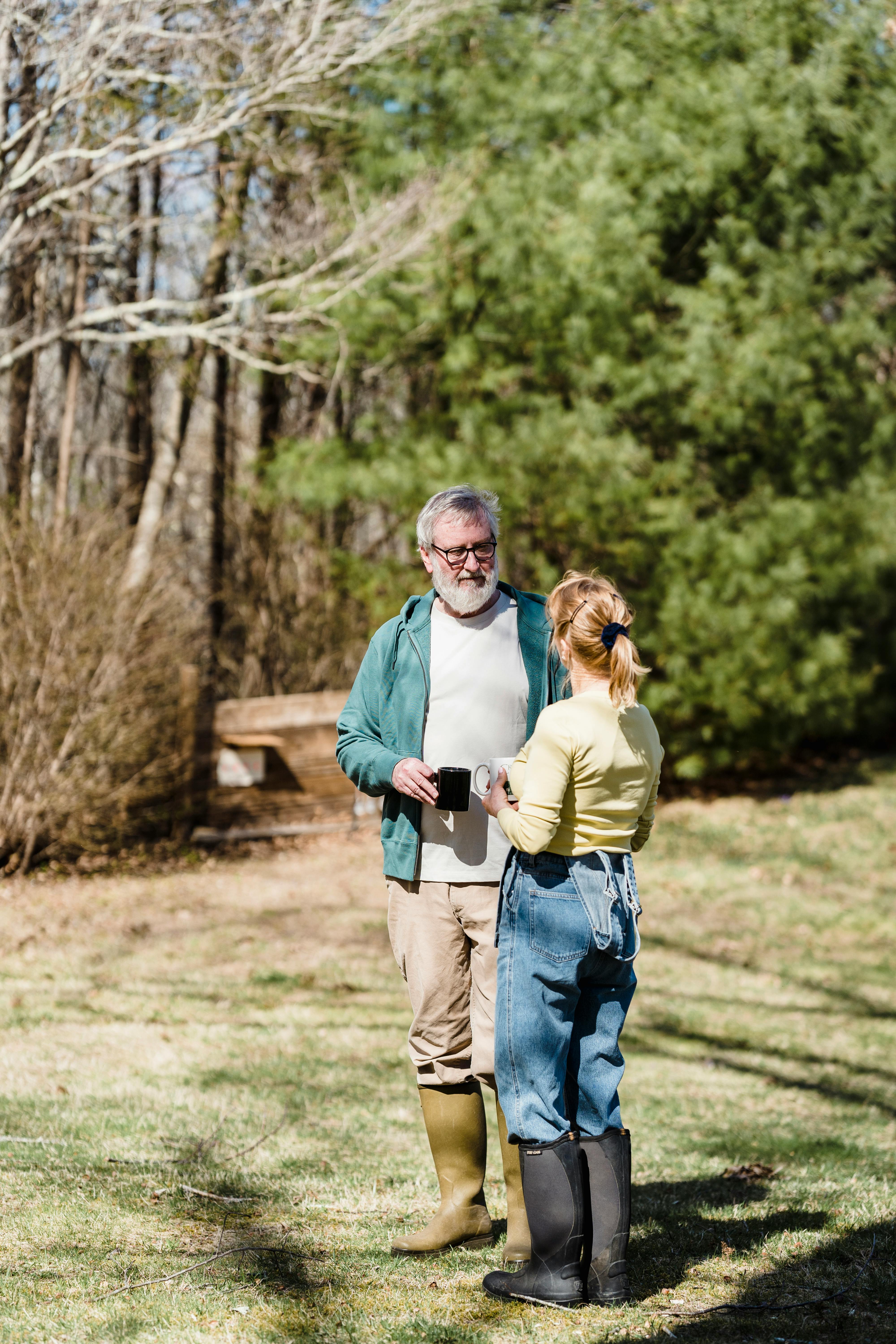 mature gardeners with hot drinks in countryside