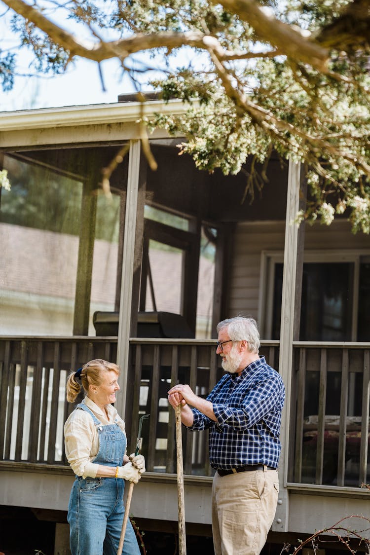 Mature Couple With Garden Tools In Countryside