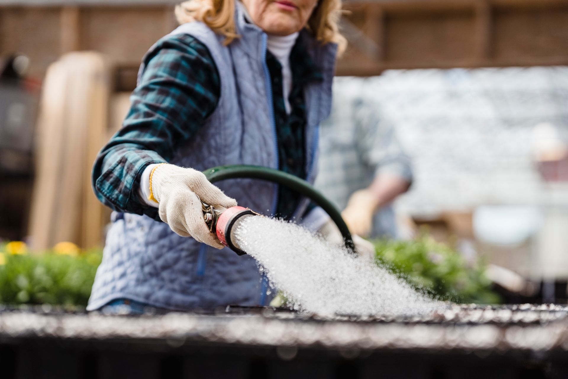 Faceless woman watering planted seeds